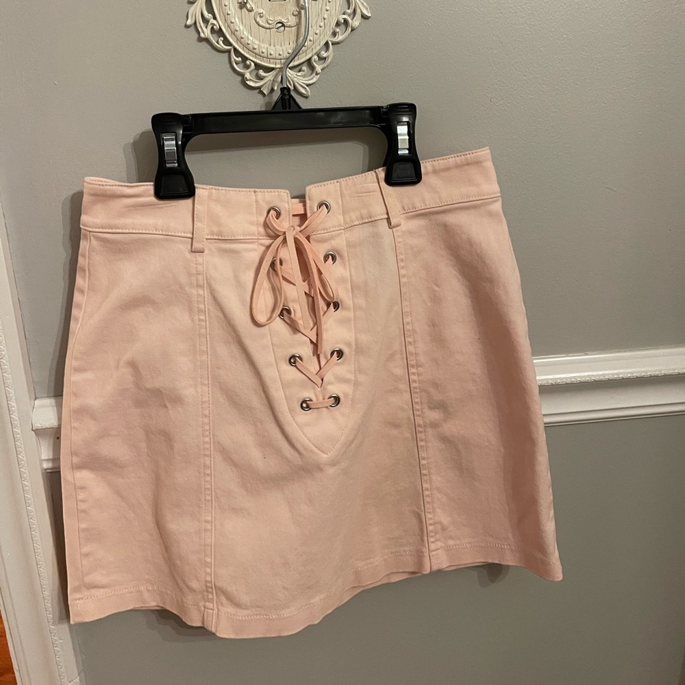 Light pink mini skirt. Tie up front with a zipper back.
